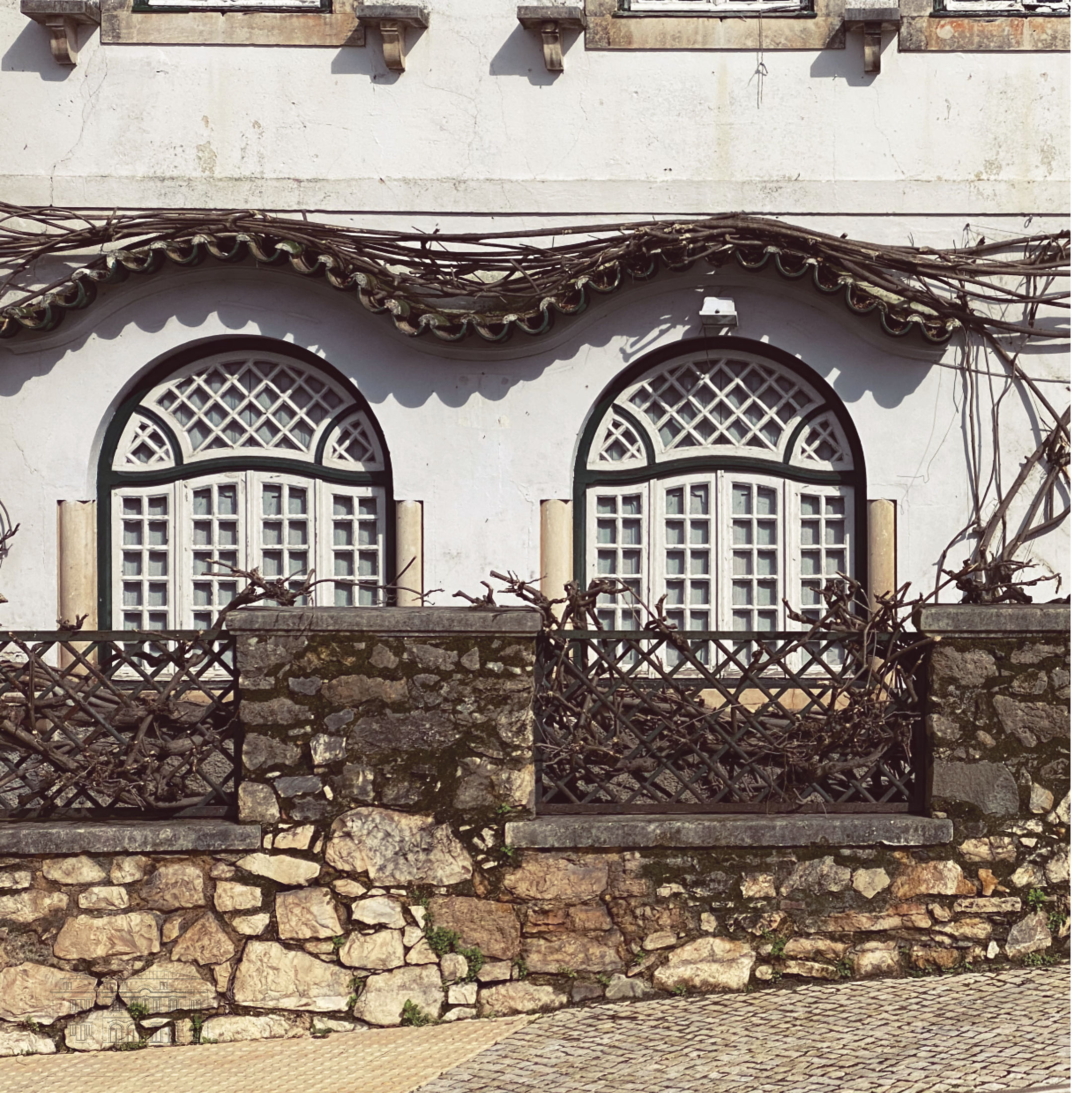photograph — the pre-existence: arched windows over the stone wall